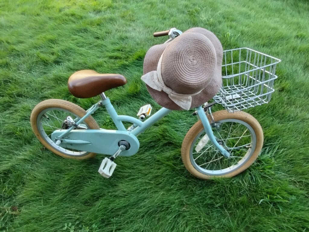 パステルブルーの自転車に麦わら帽子
